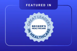 A blue badge with the words Great Leaders in Healthcare and Becker’s Healthcare in the center, above which is the text “Featured In,” set against a blue abstract background.