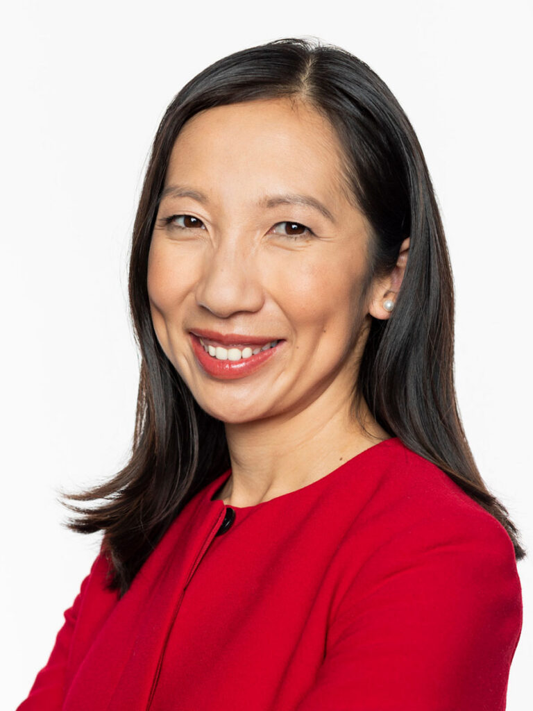 Dr. Leana Wen. A woman with straight black hair wearing a red top smiles at the camera against a plain white background, embodying the confidence and professionalism often seen at Healthcare Leadership Exchange events.