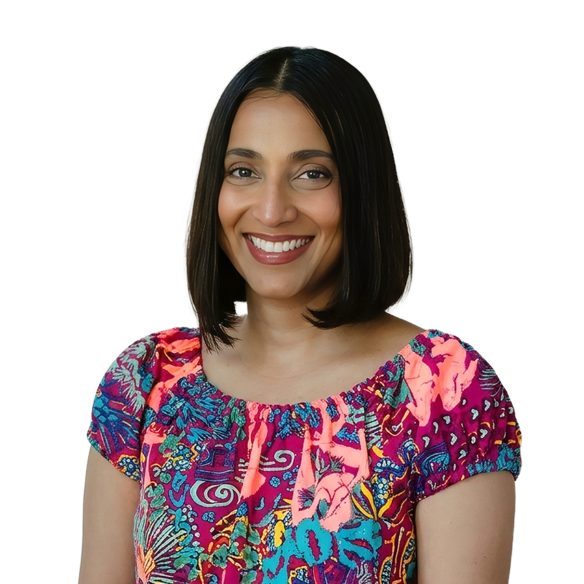 Arathi Ramani with straight, shoulder-length dark hair smiles while wearing a brightly patterned, short-sleeved top—reflecting the polished confidence of an RCM executive.