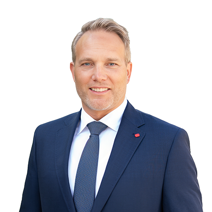 Steve Hammond in a dark blue suit, white shirt, and blue tie stands against a plain background, smiling at the camera.